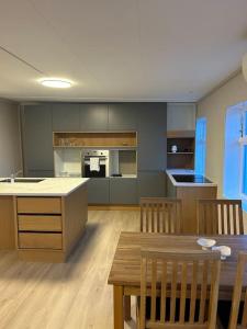 a kitchen with a table and chairs and a dining room at Sentralt hus med egen parkering in Egersund