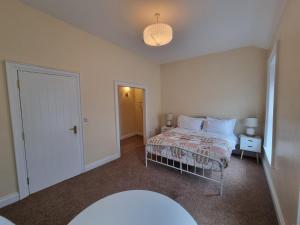 a bedroom with a bed and a door to a hallway at Derry Wall's Suite in Derry Londonderry