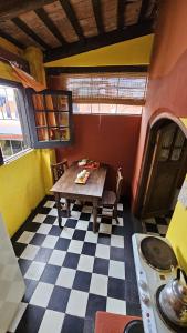 a kitchen with a table and a checkered floor at Hunab Ku Hostel in Capilla del Monte +39 photos