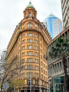 ein hohes Gebäude mit einem Uhrturm darüber in der Unterkunft Radisson Blu Plaza Hotel Sydney in Sydney