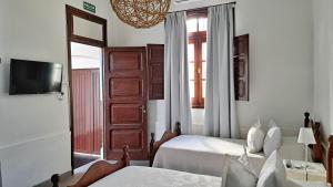 1 dormitorio con 2 camas, espejo y puerta en Casa Kolla, en Salta