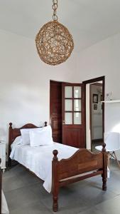 a bedroom with a bed and a chandelier at Casa Kolla - 2 bedrooms with private garage in downtown Salta in Salta +5 photos