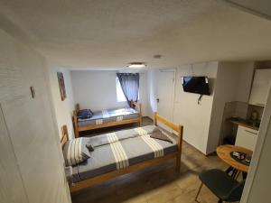 a small room with two beds and a television at No name in Jajce