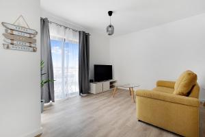 a living room with a yellow chair and a television at 13-Esteva Resorts RC-B Aljezur 5 min to the Beach in Aljezur