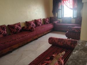 a living room with red couches and a window at Maison avec piscine pour famille au région de safi in Safi