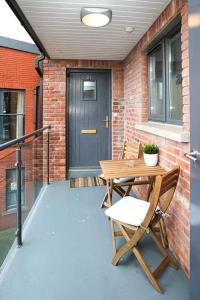 d'une terrasse avec une table en bois et 2 chaises. dans l'établissement Funky City Apartment - Secure Parking - WiFi - Sleeps 6 - No Parties, à Belfast