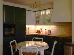 a kitchen with green cabinets and a table and chairs at Stara Praga in Warsaw