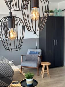 a living room with two chandeliers and a chair at De schelp 71, Free parking in Zandvoort