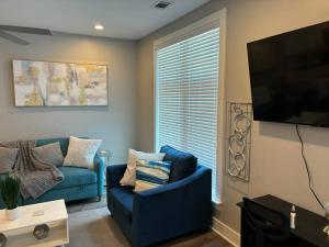 ein Wohnzimmer mit einem blauen Sofa und einem Flachbild-TV in der Unterkunft Gated Hideaway in Greenville in Greenville