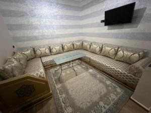 Cette chambre dispose d'un canapé et d'une télévision murale. dans l'établissement Maison montagne à Aqesri, à Annsri