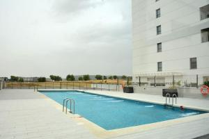 a swimming pool in front of a building at Apartamento RivasCenter in Rivas-Vaciamadrid