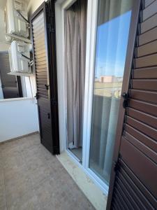 an open door to a balcony with a window at La casa di Chloé in Alezio