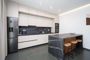 a kitchen with white cabinets and a stainless steel refrigerator at Family friendly house with a swimming pool Bibinje, Zadar - 23364 in Bibinje