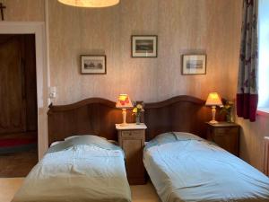 two beds in a room with two lamps on tables at Gîte Charmant au Cœur de la Nature près du Mans, 6 Pers., Domaine Historique - FR-1-410-319 in Teillé