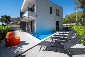 a group of chairs sitting on a patio next to a swimming pool at Family friendly house with a swimming pool Bibinje, Zadar - 23363 in Bibinje
