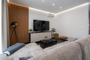 a living room with a couch and a flat screen tv at Family friendly house with a swimming pool Bibinje, Zadar - 23363 in Bibinje