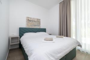 a bedroom with a large bed with white sheets at Family friendly house with a swimming pool Bibinje, Zadar - 23363 in Bibinje +19 photos