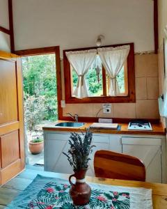 a kitchen with a table and a sink and a window at Tierras del Sur I un calido lugar in Villa La Angostura