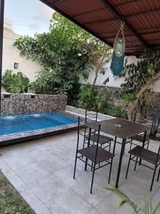 un patio con tavolo e sedie accanto alla piscina di Cozy House with Pool and AC Casa Armando a Cozumel