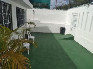 a patio with a green floor and a chair on it at Cozy House with Pool and AC Casa Armando in Cozumel
