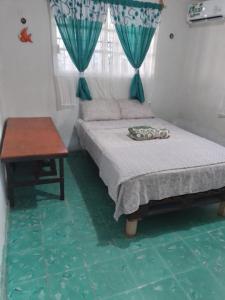 una camera da letto con un letto, un tavolo e una finestra di Cozy House with Pool and AC Casa Armando a Cozumel Altre 5 foto