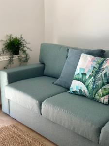 un divano blu in soggiorno con cuscino di Apartamento Estrellas de Mar a Ribeira