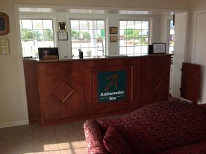 a large wooden reception desk in a room with at Ambassador Inn in Fayetteville