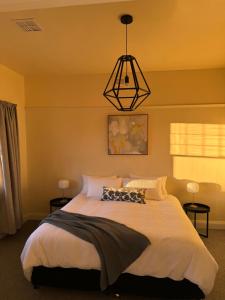 Un dormitorio con una cama grande y una lámpara de araña. en 11Eardley - 2bedroom house - Free parking - 3 minutes from CBD, en Kings Park