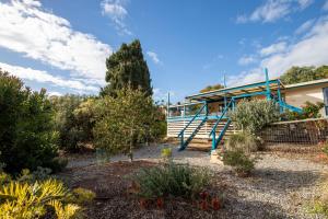 a house with a blue railing in a garden at 25 Elizabeth Crescent in Carrickalinga