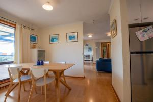 a kitchen and dining room with a table and chairs at 25 Elizabeth Crescent in Carrickalinga