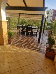 une terrasse avec une table et des bancs sous un parasol dans l'établissement Appartement MARINA AP4 SAIDIA, à Saïdia 3 autres photos