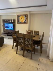 a dining room with a table and chairs and a tv at Oga Guasu casa con piscina exclusiva in Puerto Iguazú