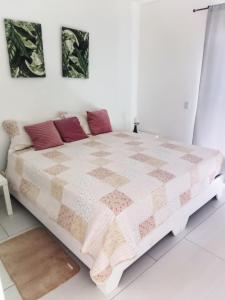a white bedroom with a large bed with red pillows at Ocean Bliss in Sosúa +14 photos