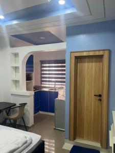 Cette chambre dispose d'une cuisine avec une porte et une table. dans l'établissement Private, Cozy, CityCentre Studio II, à Abuja