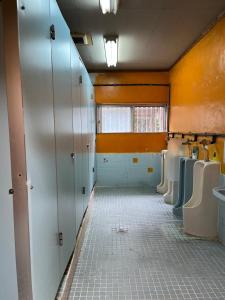 a bathroom with a row of urinals and toilets at やどバンブー in Hateruma +37 photos