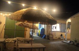 a large straw umbrella in the middle of a room at やどバンブー in Hateruma