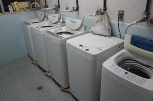 a group of three washing machines in a laundry room at やどバンブー in Hateruma