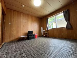 an empty room with a television and a window at やどバンブー in Hateruma