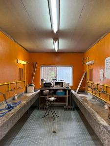 an office with an orange wall with a desk at やどバンブー in Hateruma