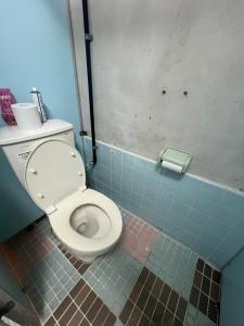 a bathroom with a toilet in a tiled room at やどバンブー in Hateruma