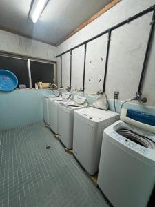 a laundry room with a row of washers and dryers at やどバンブー in Hateruma
