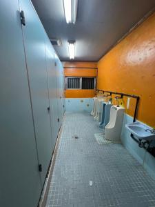 a bathroom with a row of urinals and sinks at やどバンブー in Hateruma