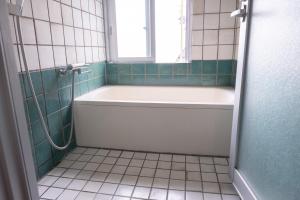 a bathroom with a bath tub and a window at 20C Ryukyu in Nakijin