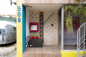 a store front with a door with a surfboard on the wall at 20C Ryukyu in Nakijin