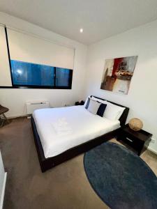 a bedroom with a large bed and a large window at Ascot Vale - Lovely 2 bedroom townhouse close to everything! in Ascot Vale