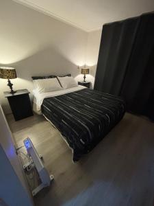 a bedroom with a large bed and two lamps at Departamento en condominio in Pucón