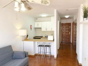 a living room with a couch and a kitchen at Apartamento Elisa en Garden City con piscina climatizada in Playa Fañabe