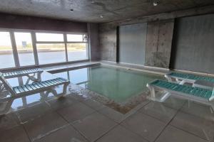 a swimming pool with two benches in a room at Tango 4C in Victoria