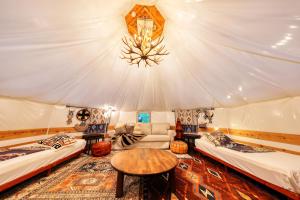 a room with two beds and a table in a tent at Retreat Camp Mahoroba in Fujikawaguchiko
