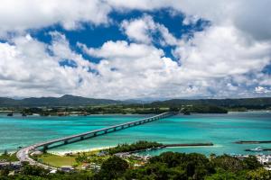 a bridge over a body of water with blue water at 20C Ryukyu in Nakijin